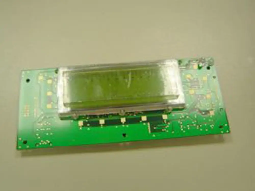 Grüne Leiterplatte mit integrierter LCD-Anzeige, gefertigt von Remeha, zeigt mögliche elektronische Verbindungen und Schaltflächen für Benutzerinteraktionen.
